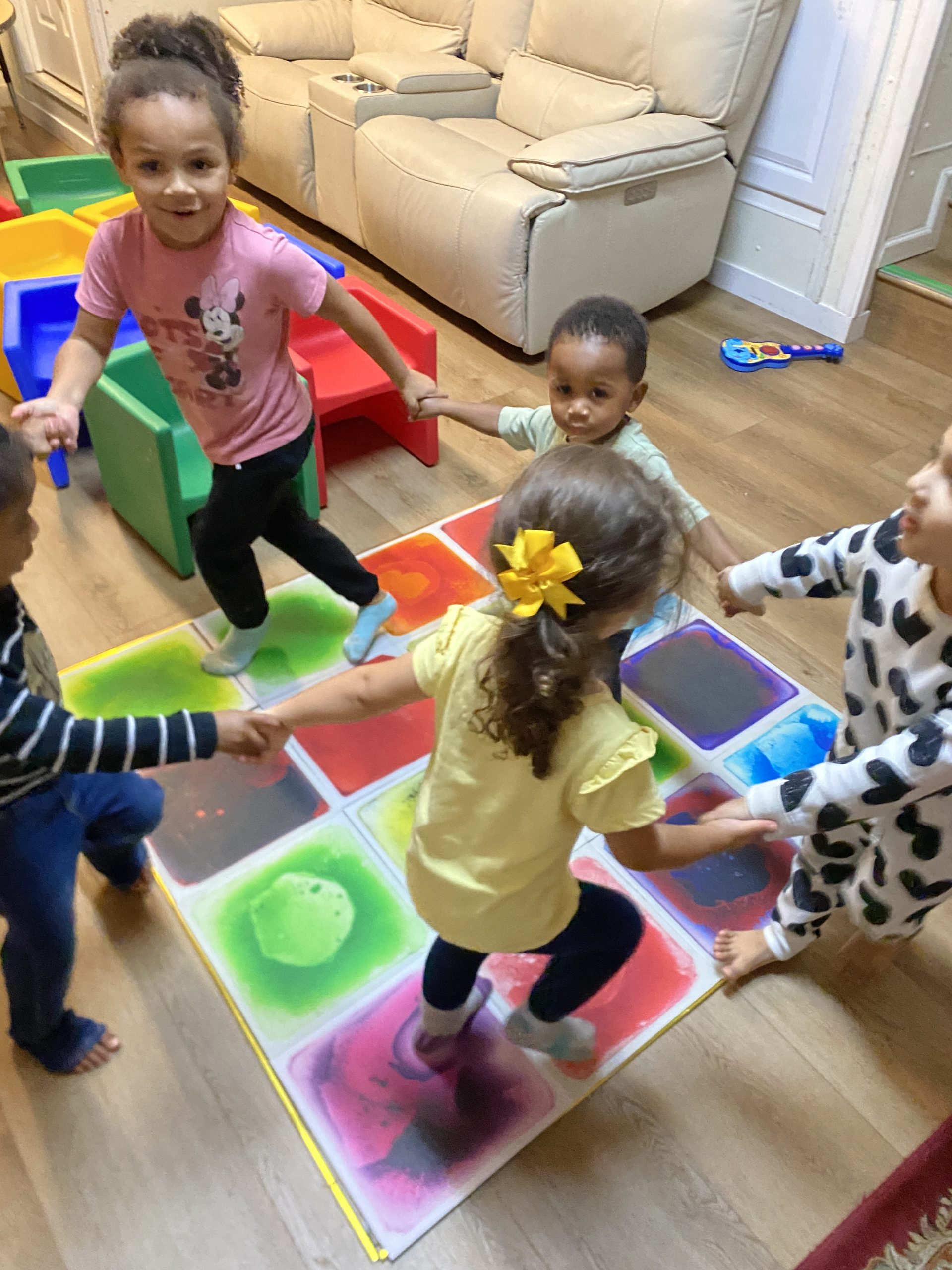 Children joyfully playing on a vibrant floor surrounded by various toys, fostering creativity and imagination.